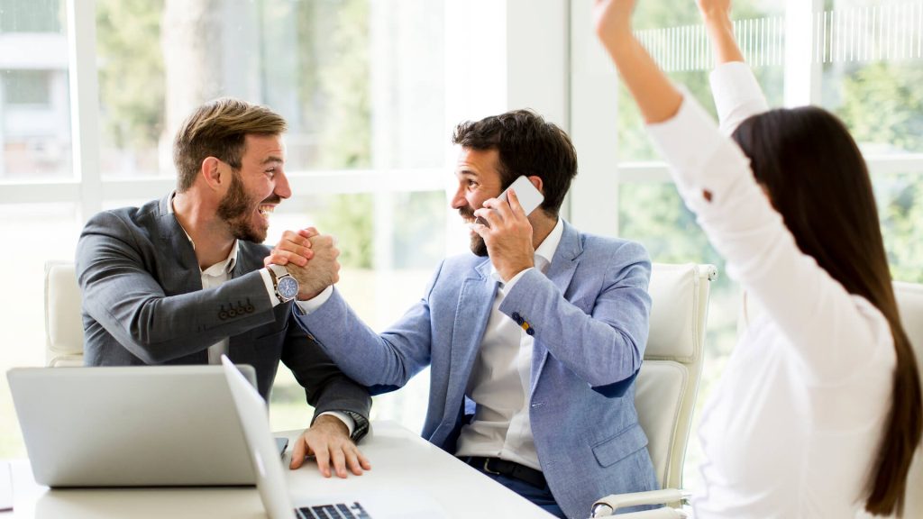 two men on a sales training course shaking hands
